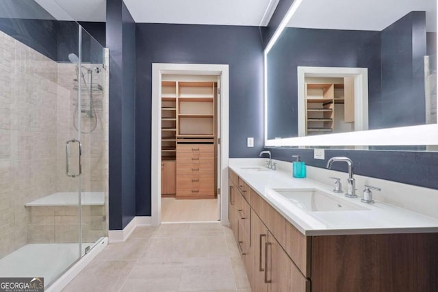 bathroom with tile patterned floors, double sink vanity, and walk in shower