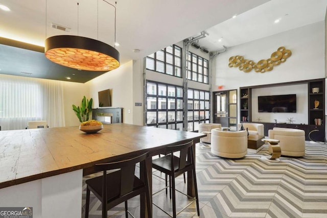 dining space featuring a towering ceiling