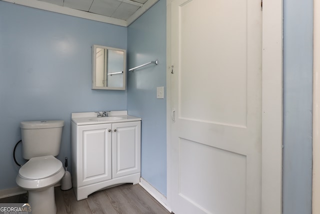 bathroom with wood-type flooring, toilet, and vanity