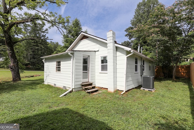 exterior space with central air condition unit and a yard