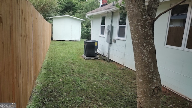 view of yard featuring a storage shed and central AC