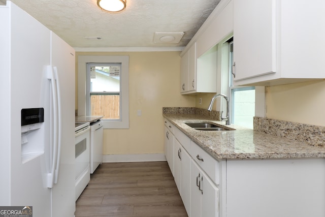 kitchen featuring white appliances, sink, light hardwood / wood-style floors, a textured ceiling, and white cabinetry