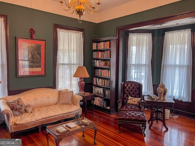 living area with hardwood / wood-style floors and a notable chandelier