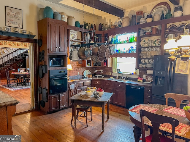 kitchen featuring sink, backsplash, black appliances, beam ceiling, and light hardwood / wood-style flooring