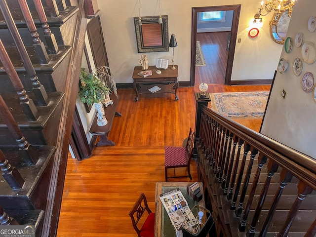 hall with wood-type flooring and a notable chandelier