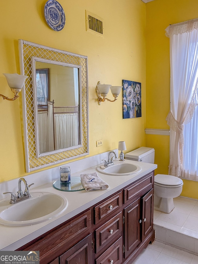 bathroom with tile patterned floors, toilet, vanity, and plenty of natural light