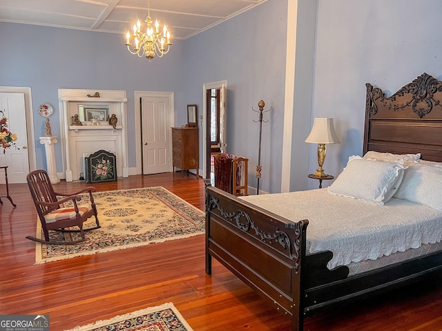 bedroom featuring hardwood / wood-style flooring, coffered ceiling, and a notable chandelier