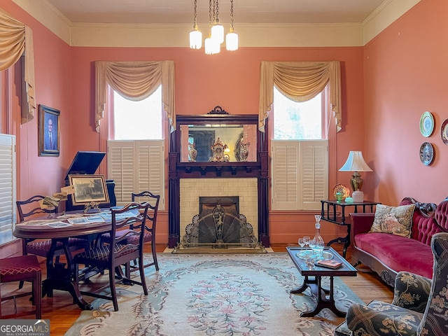 living room with hardwood / wood-style flooring, crown molding, plenty of natural light, and a fireplace