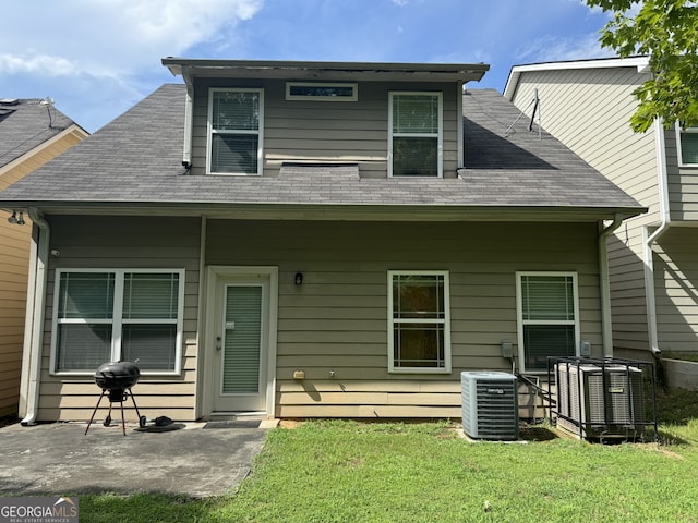 view of front of house featuring cooling unit, a patio area, and a front lawn