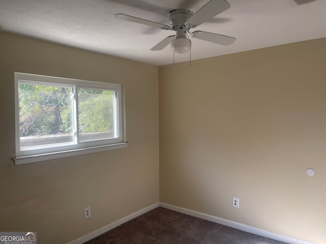 unfurnished room featuring dark colored carpet and ceiling fan