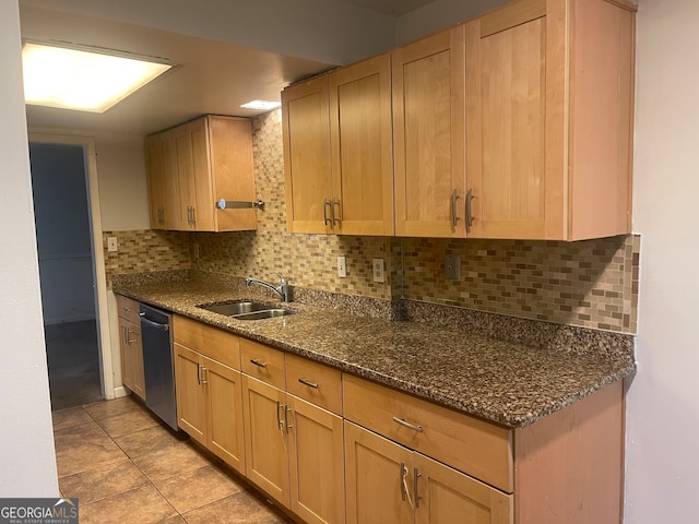 kitchen with dark stone countertops, sink, dishwasher, backsplash, and light tile patterned floors