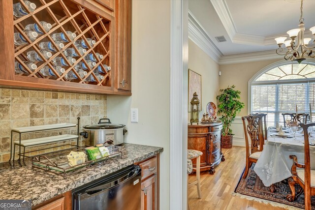 kitchen with decorative light fixtures, a chandelier, light wood-type flooring, dishwasher, and a raised ceiling