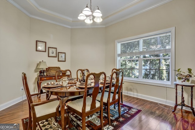 dining area featuring a raised ceiling, ornamental molding, dark hardwood / wood-style floors, and a chandelier