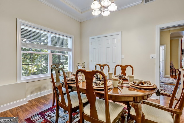 dining room with a chandelier, hardwood / wood-style flooring, and ornamental molding