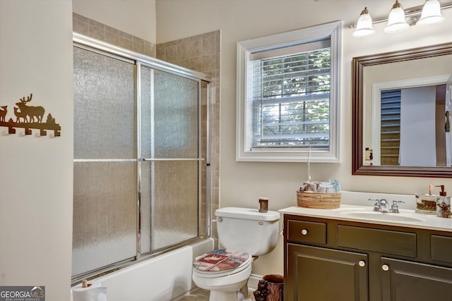 full bathroom with toilet, enclosed tub / shower combo, and vanity