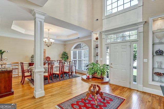 foyer featuring a raised ceiling and light hardwood / wood-style floors