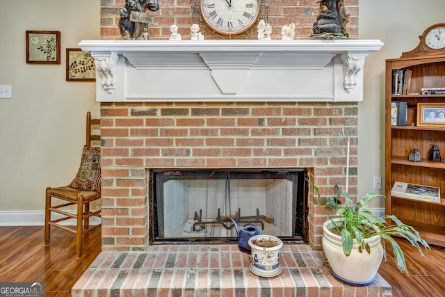 details featuring hardwood / wood-style flooring and a brick fireplace