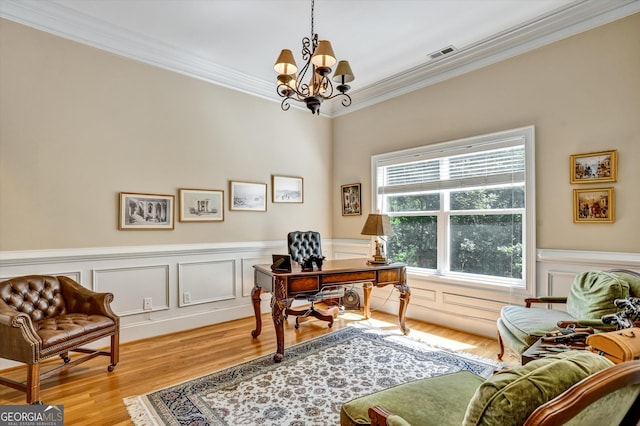 office space featuring crown molding, light wood-type flooring, and a notable chandelier