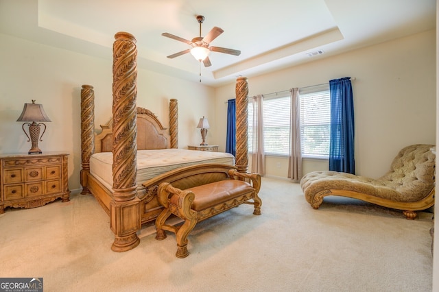 carpeted bedroom featuring ceiling fan and a raised ceiling