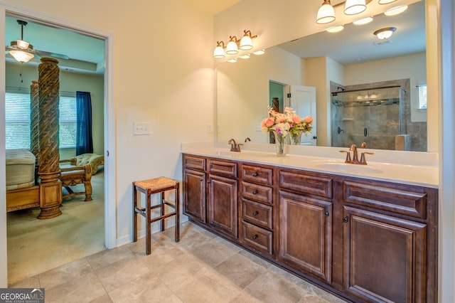 bathroom with a shower with shower door, tile patterned floors, double sink vanity, and ceiling fan