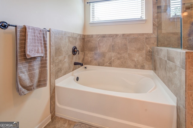 bathroom featuring tile patterned floors and a tub to relax in