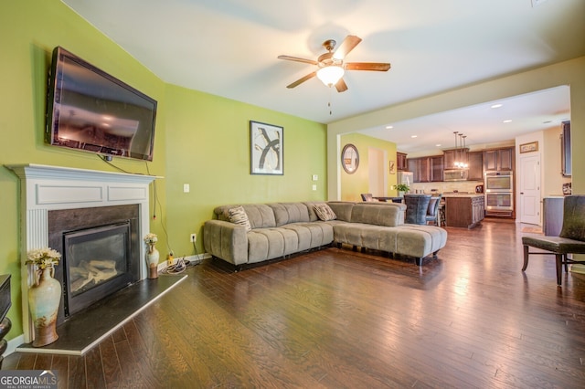 living room featuring dark wood-type flooring and ceiling fan