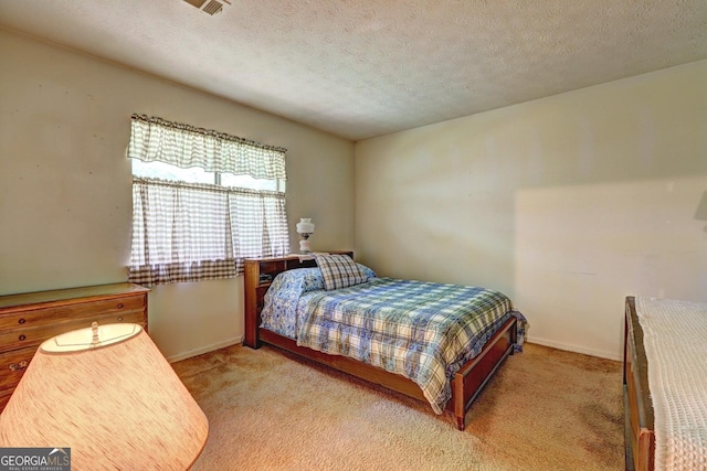 bedroom with light carpet and a textured ceiling