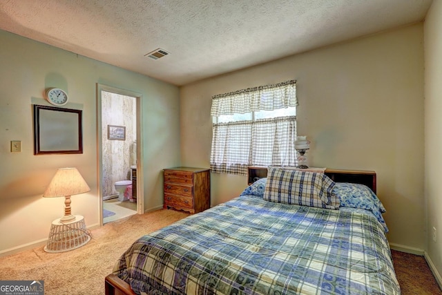 bedroom featuring carpet flooring, connected bathroom, and a textured ceiling