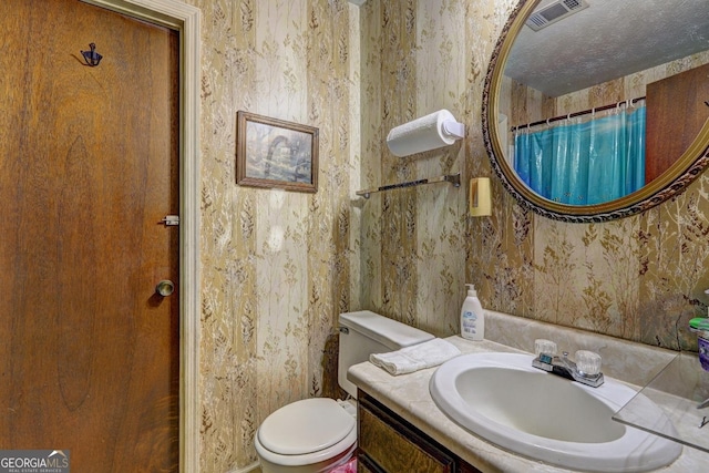 bathroom with vanity, toilet, and walk in shower