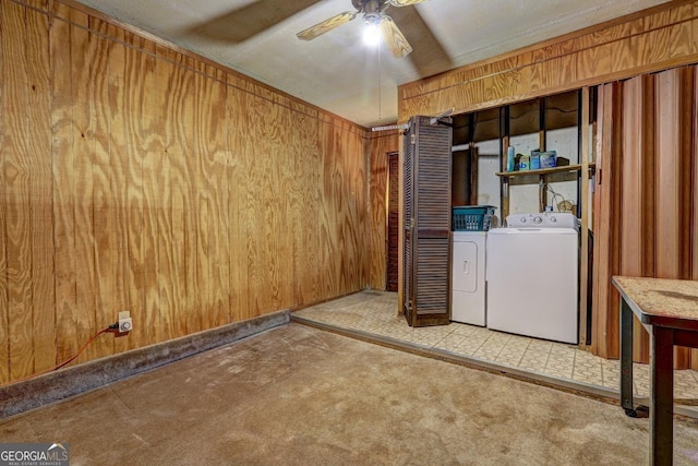 clothes washing area with ceiling fan, independent washer and dryer, wooden walls, and carpet