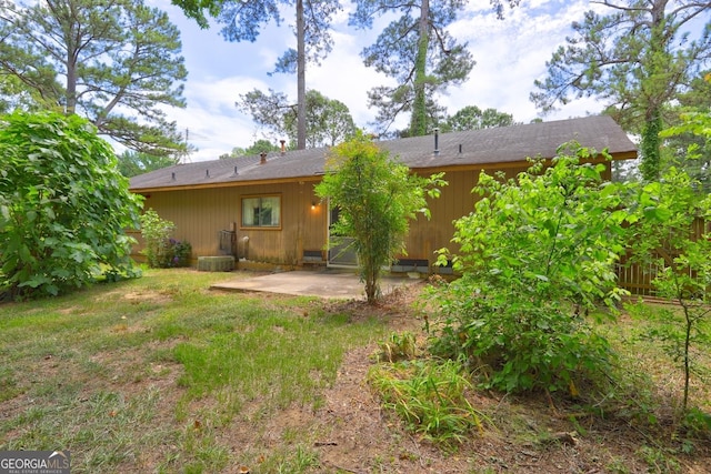 rear view of house featuring a yard and a patio area