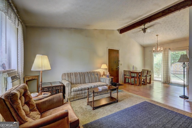 living room with an inviting chandelier, wood-type flooring, vaulted ceiling with beams, cooling unit, and a textured ceiling