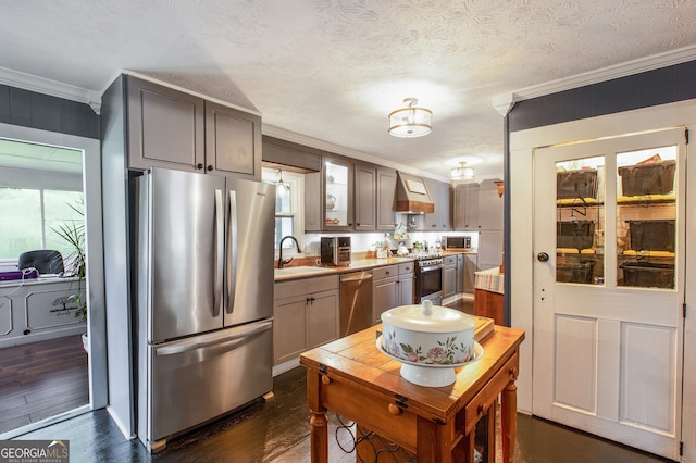 kitchen featuring ornamental molding, appliances with stainless steel finishes, dark hardwood / wood-style flooring, and custom exhaust hood