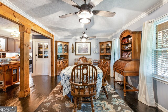 living room featuring a textured ceiling, ceiling fan, ornamental molding, and dark hardwood / wood-style flooring