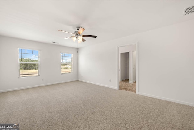 empty room featuring light colored carpet and ceiling fan