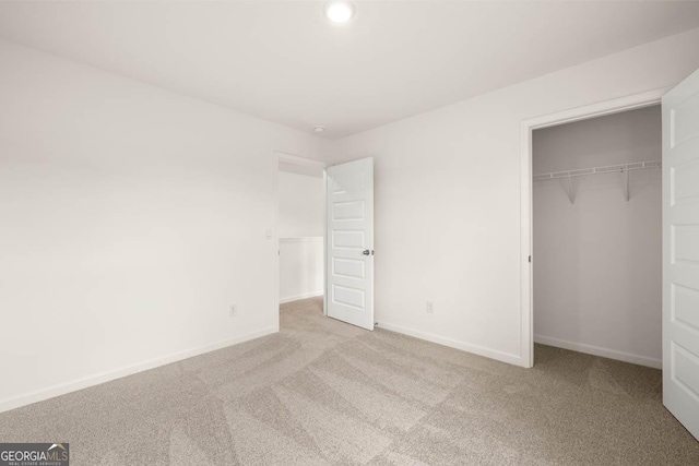 unfurnished bedroom with a closet and light carpet