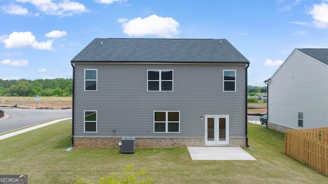 rear view of property featuring cooling unit, a yard, a patio area, and french doors