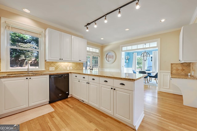 kitchen featuring sink, kitchen peninsula, light hardwood / wood-style flooring, white cabinetry, and black dishwasher