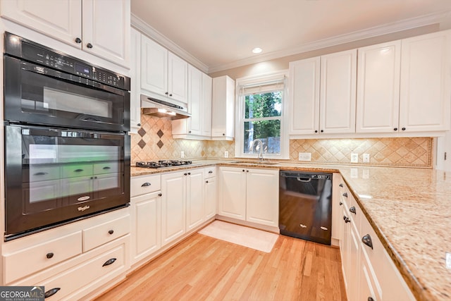 kitchen with light hardwood / wood-style floors, black appliances, sink, and white cabinetry