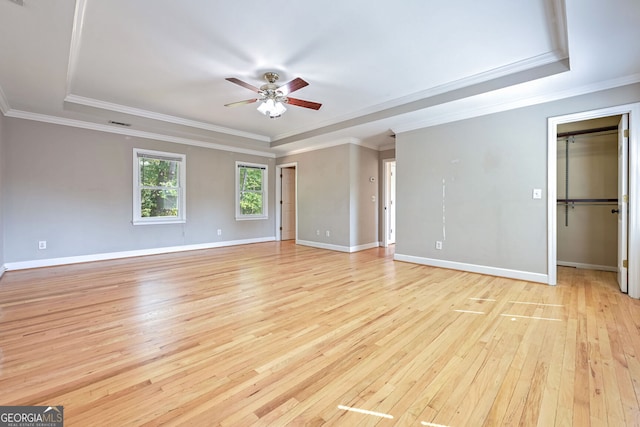 unfurnished room featuring ornamental molding, a tray ceiling, light hardwood / wood-style flooring, and ceiling fan