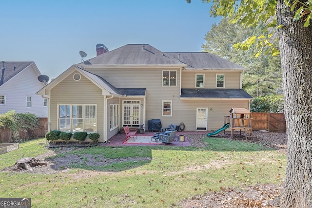 back of property with a yard and a patio area