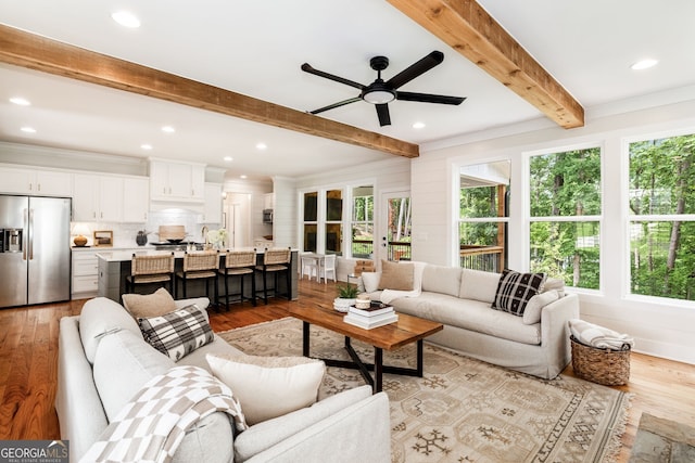 living room featuring light hardwood / wood-style flooring, a wealth of natural light, and ceiling fan