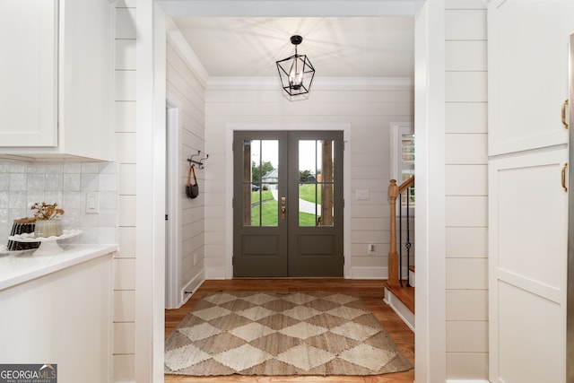 entryway featuring ornamental molding, wood-type flooring, and french doors