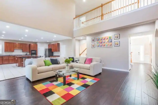 living room featuring dark hardwood / wood-style floors and a towering ceiling