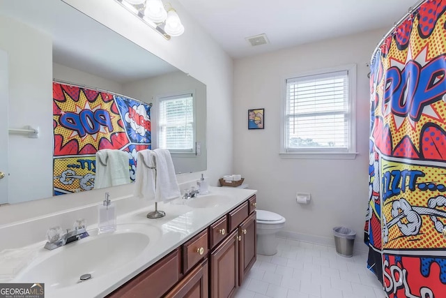 bathroom featuring dual vanity, toilet, tile patterned floors, and plenty of natural light