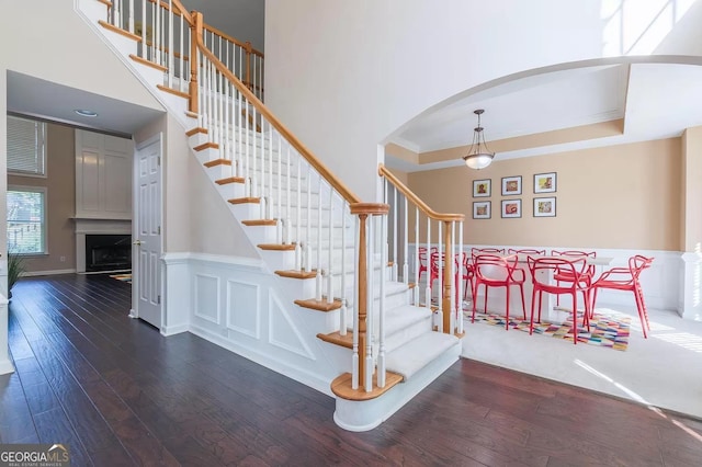 staircase with hardwood / wood-style flooring and ornamental molding