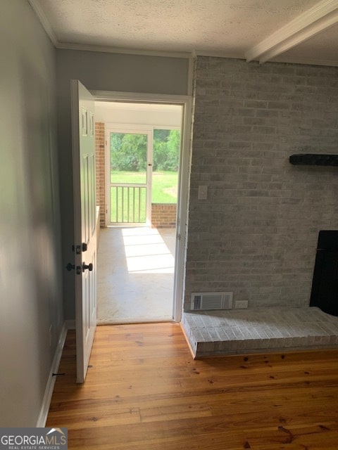 entryway with a textured ceiling, hardwood / wood-style floors, and brick wall