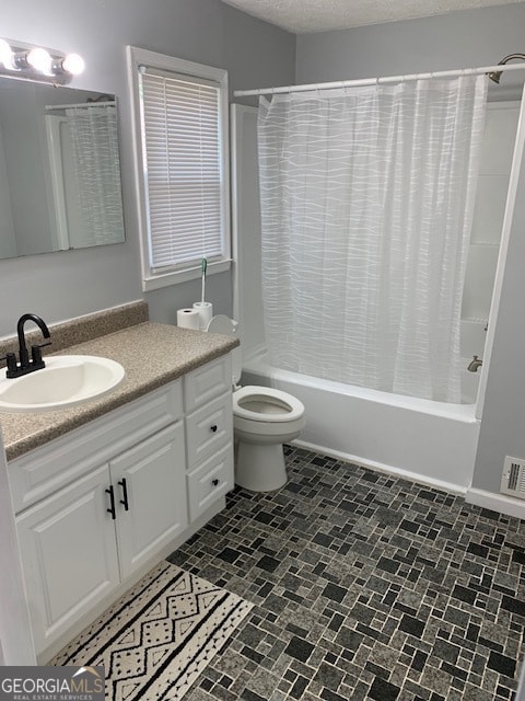 full bathroom featuring vanity, tile patterned floors, a textured ceiling, shower / bath combination with curtain, and toilet