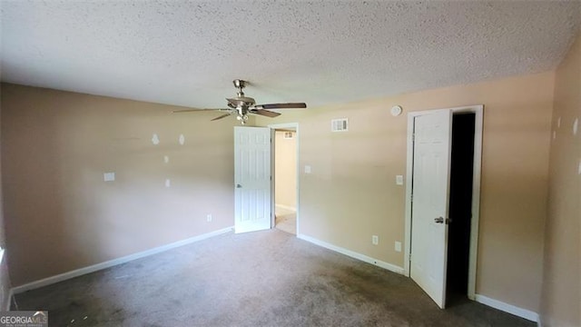 unfurnished room with ceiling fan, dark carpet, and a textured ceiling