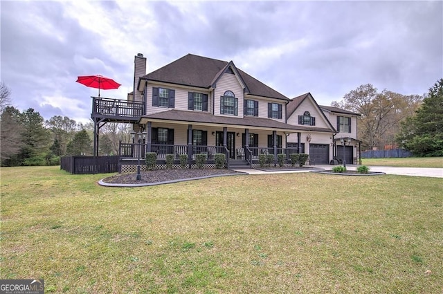 view of front of house with a front lawn, covered porch, and a garage